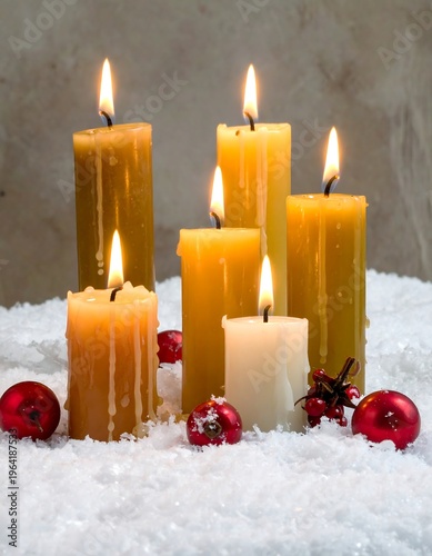 Candles and Christmas Ornaments on Snow - A Festive Holiday Scene.