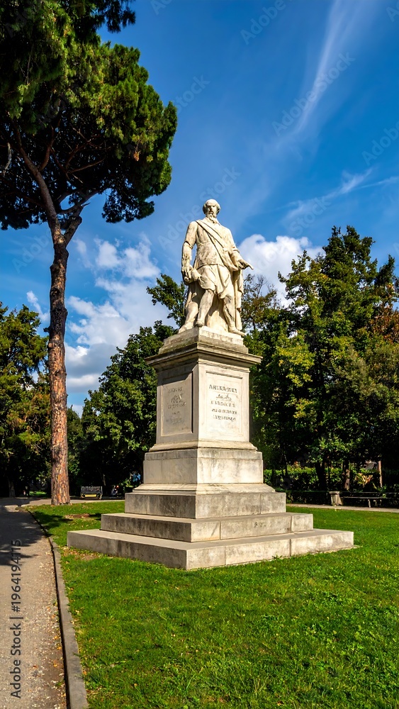 Obraz premium Marble statue on stone pedestal in park setting with tree and blue sky, sunny day