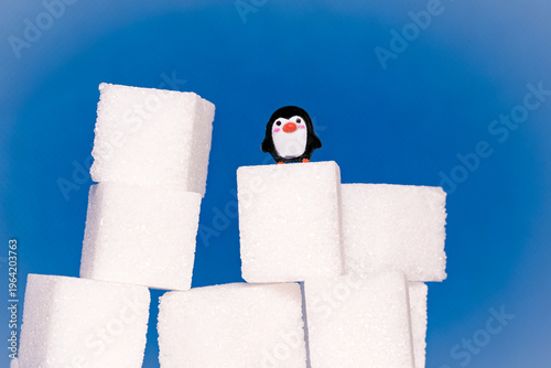 Toy penguins perched on sugar cubes as they race to the top