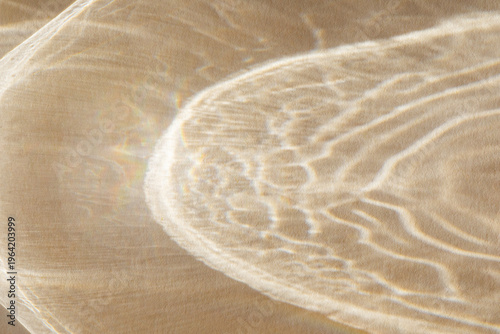 Shiny golden abstract shadows background from sunlight and glare. Modern caustic background from reflection effects for product presentation and design card.