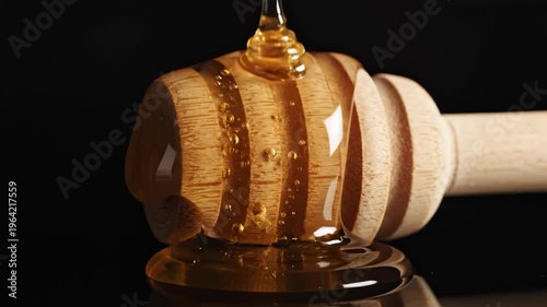 Golden Honey Dripping Onto Wooden Honey Dipper in Slow Motion Against Black Background
