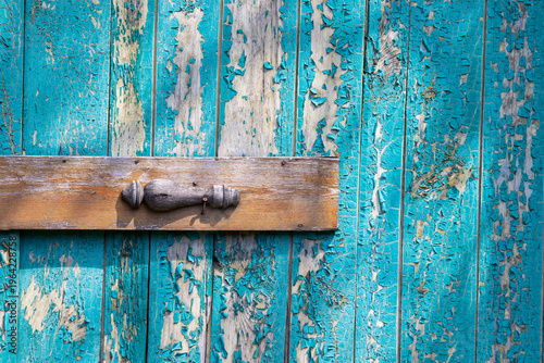Peeling blue paint on wooden planks with small cross board. Background