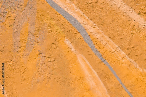 Light orange paint in large strokes on a flat surface. Background