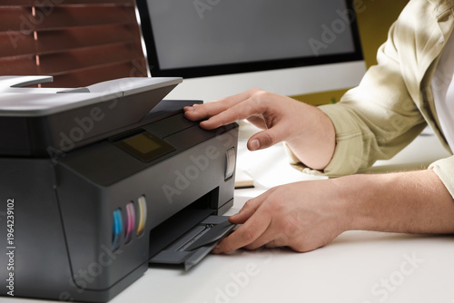 Konstfotografi Man working with printer at white desk indoors, closeup