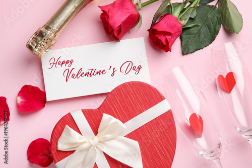 Happy Valentine's day card, flute glasses, roses and heart-shaped gift box on pink background