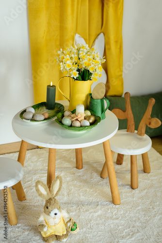 Bright Easter-themed children's room interior with a white table, bunny ear chairs, yellow spring flowers, and festive egg decorations in a minimalist Scandinavian style