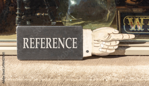 References or reference symbol. Concept word Reference on beautiful black wooden sign as a hand. Beautiful store front background. Business references or reference concept. Copy space.