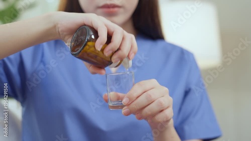 Caregiver nurse elderly care home medicine pill dosage cup patient pour medicine into cup, healthcare bottle gently poured from brown glass, calm steady gentle support compassion in daily routine