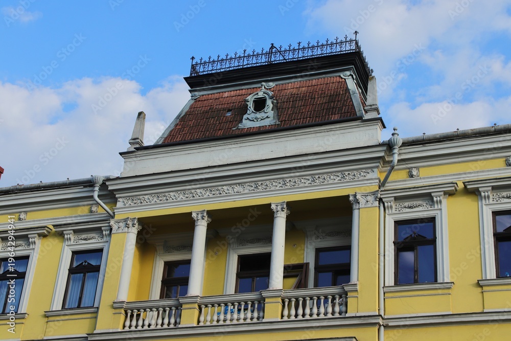 Obraz premium Elegant Historic Building Facade with Ornate Windows and Architectural Details