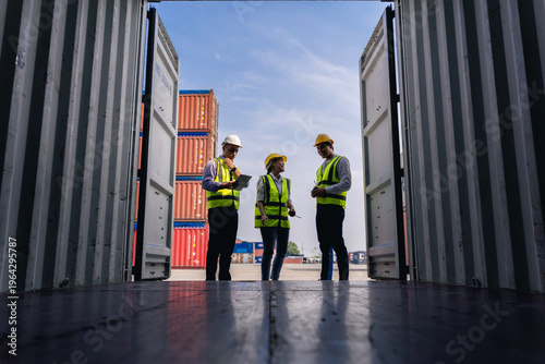 Team of workers discussing logistics operations at container yard