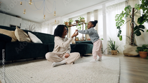 Valokuva Young Black mother sitting on the floor, connecting with her toddler daughter wh
