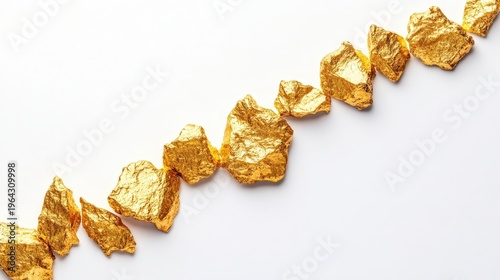 Raw gold nuggets lined up on a clean white background, symbolizing wealth and precious investment opportunities
