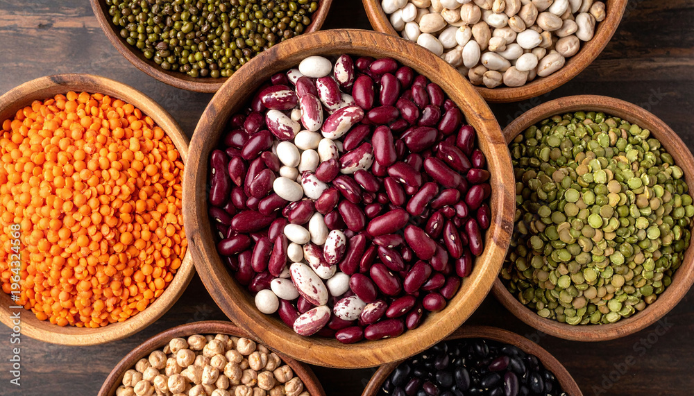 Fototapeta premium Explore a vibrant array of healthy legumes in rustic wooden bowls. Perfect for plantbased nutrition concepts, organic cooking blogs, and showcasing various sustainable protein sources.