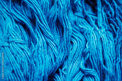 Close-up of vibrant blue wool yarn texture, detailed view of soft textile fibers, natural light, background for knitting and craft concepts