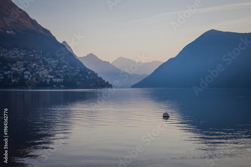 Sunrise autumnal panorama of Lugano lake. Swiss mountains in the background. Lugano, Ticino, Switzerland