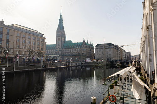 HAMBURG, GERMANY - MARCH 07, 2026: Scenic view of Hamburg Rathaus City Hall and Kleine Alster canal with Alsterarkaden arcades and reflections on water under clear sky