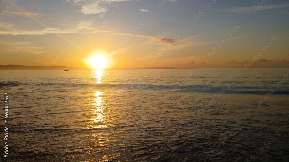 Fototapeta premium Panoramic view of golden sunrise over the calm ocean horizon.