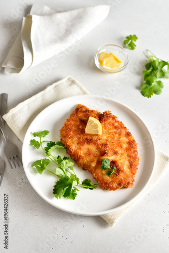 Chicken schnitzel on white plate