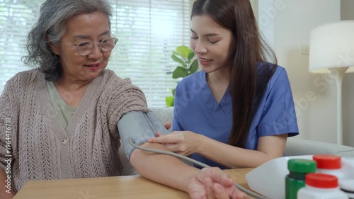 Caregiver elderly home care nurse healthcare blood pressure patient support at home, cuff monitor checkup and health check, compassion and steady help, medication on table, living room wellness
