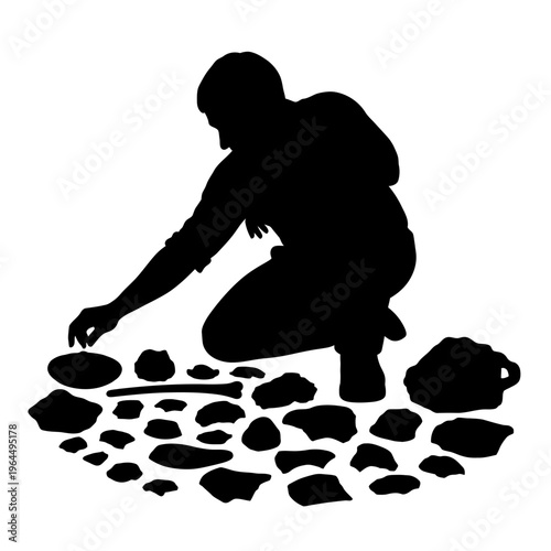Silhouette of an Archaeologist Examining Ancient Artifacts on the Ground.