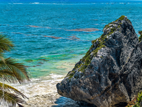 Large limestone rock formation on the shore of Tulum beach in Mexico.