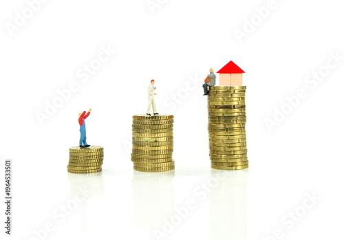 Miniature People On Stacks Of Coins With House Model Representing Wealth, Savings And Property Inequality