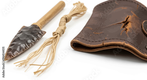 A close-up of indigenous artifacts a stone knife, tied bundle, and leather pouch