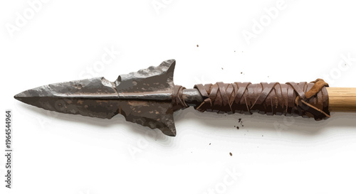 A close-up of an arrow with a stone arrowhead bound to a wooden shaft
