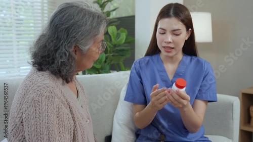 Caregiver elderly home care nurse medication support healthcare guidance explain consultation guides senior sofa, explaining pill bottle for daily care in living room with clear instruction