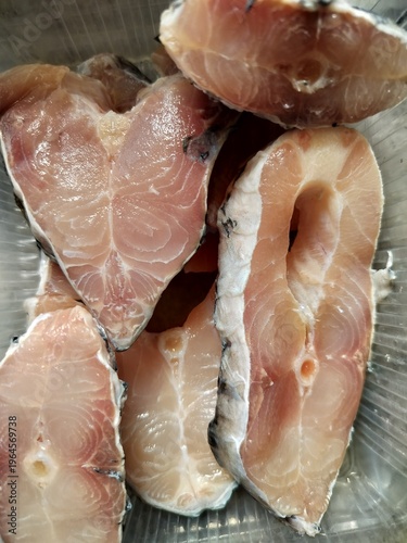 Raw chopped Catla fish pieces, fresh uncooked cleaned Asian freshwater fish in the carp family Cyprinidae display in close view.