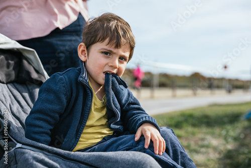 Young boy biting jacket sleeve showing anxiety