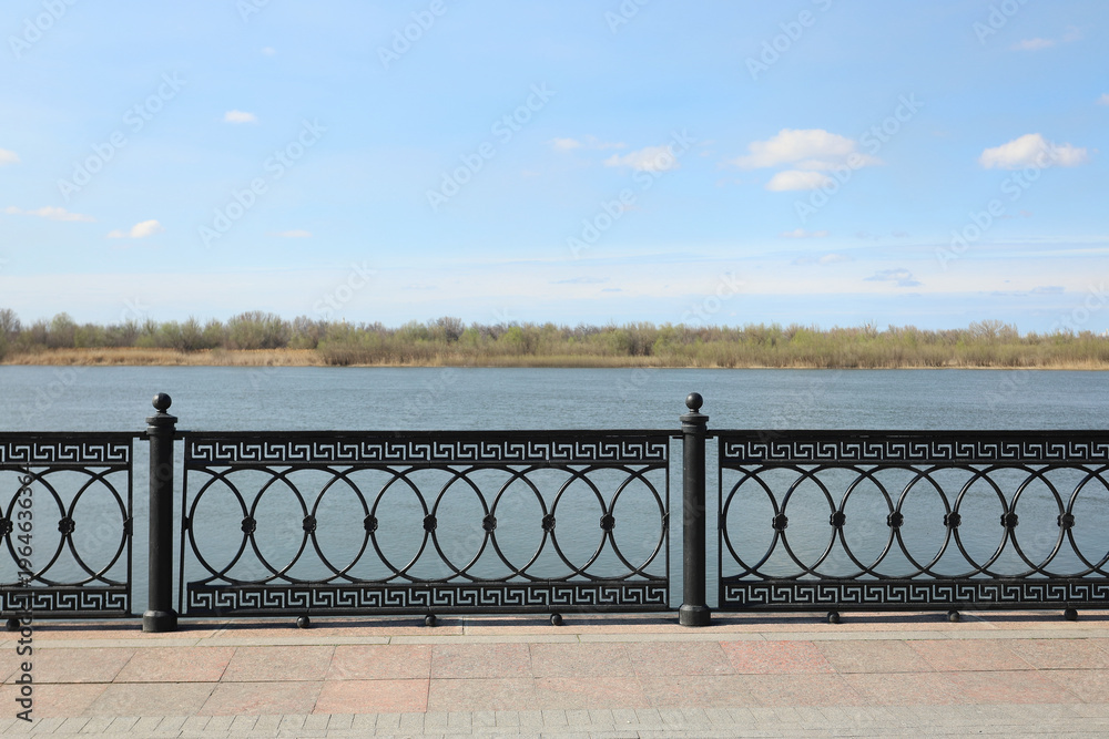Ταπετσαρία openwork cast-iron casting on the embankment, sunny day, far shore,