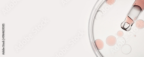 Pipette dropping serum into petri dish, banner format