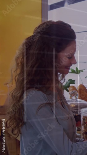 Vertical video: Woman smiling then reaching for jar at cafe bar while lines crossing, taking treat