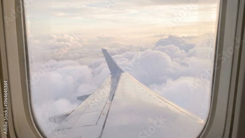 Airplane Wing over Majestic Clouds During a Serene Golden Hour Flight