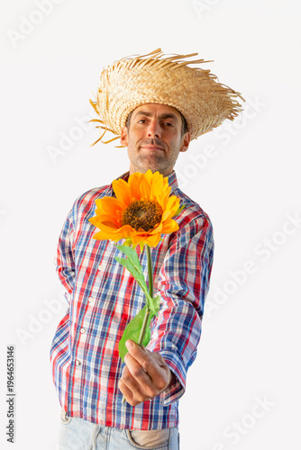 Man dressed for the June festivals in Brazil offering a flower