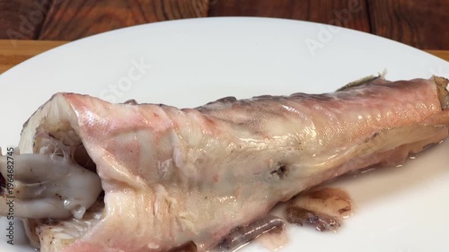 Piece of boiled kingklip on plate, top view close-up