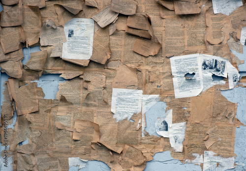 Abstract collage of vintage torn book pages on a weathered blue wall