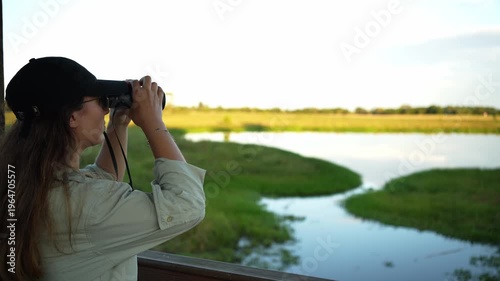 Female birdwatcher observing wildlife with binoculars