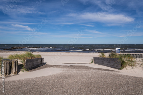 Scenic coastal landscape with marram grass dunes, white sand beach and blue sea

