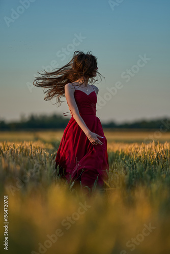 Woman rye field red dress. Happy woman in a long red dress in a beautiful cornfield. Old caste ruins in the background