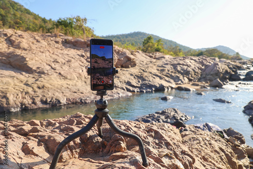 Cuadro en lienzo Smartphone on Tripod Recording Scenic Mountain River Landscape in Natural Rocky
