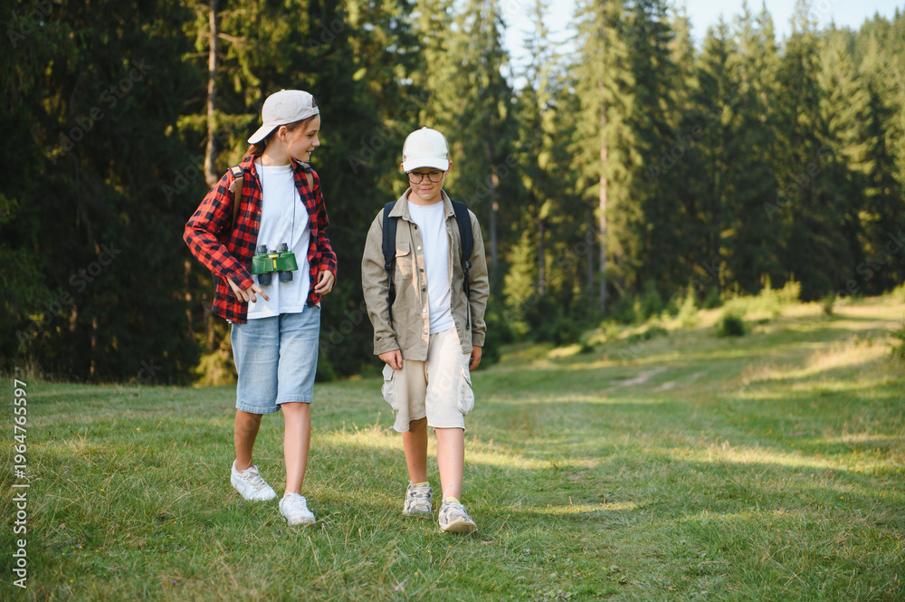 Fototapeta premium Young explorers hiking in forest, embracing nature's wonders