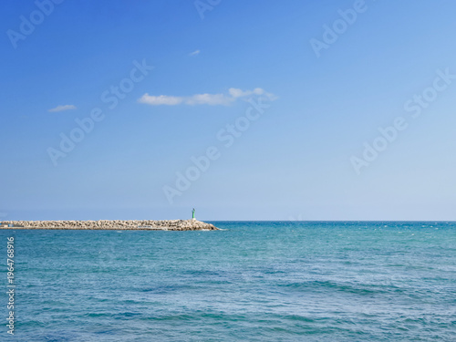 Idyllic Seaside Landscape With Tranquil Waters And Distant Lighthouse
