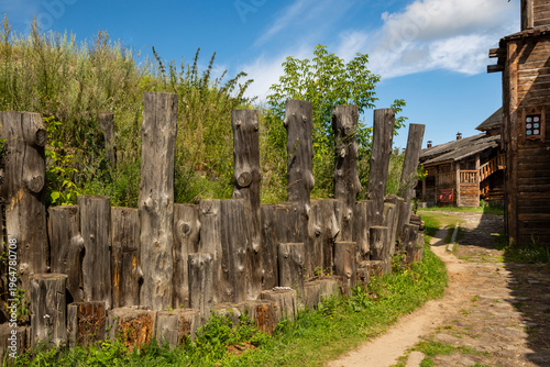 A reconstructed Old Slavic fortress, built of round, hewn logs. A bright sunny day. The courtyard is surrounded by living quarters.