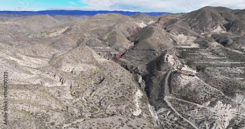 Aerial view of eroded canyon ridges and sediment formations in Tabernas Desert Spain cinematic dry landscape