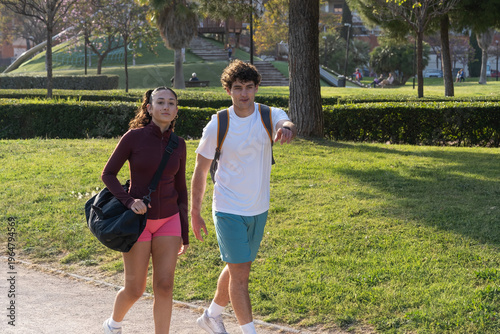 Photos Young couple walking in park wearing athletic clothes
