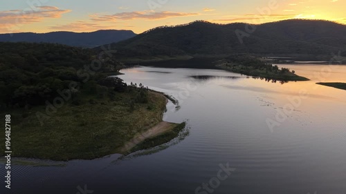 Aerial view of Cania Dam at sunset with calm water and mountain landscape
