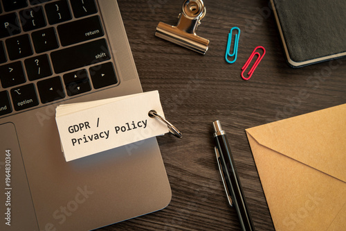 Eye-catching image of GDPR  Privacy Policy text on word card. The word stands for GDPR / Privacy Policy. Shown with laptop, clips, pen.