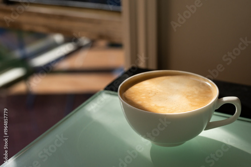 cup of tea on the table with a window in the background